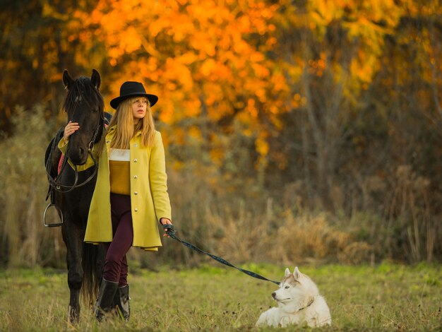 Mädchen posiert mit einem Pferd und einem Hund
