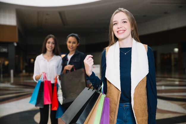 Mädchen posiert mit Taschen im Einkaufszentrum