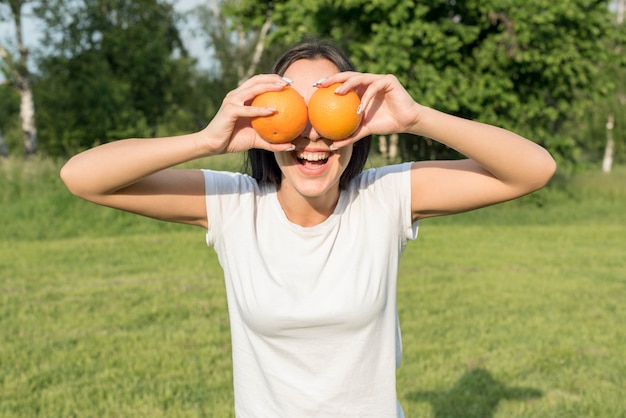 Kostenloses Foto mädchen posiert mit zwei orangen