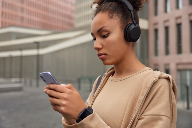 Mädchen ruht sich nach dem Training aus, benutzt das Telefon zum Online-Chatten lädt Songs in die Playlist herunter hört Audio vom Handy-Player, der mit der Handy-Anwendung verbunden ist