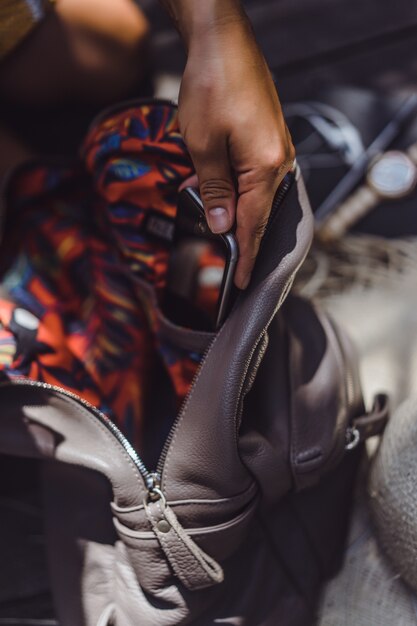 Mädchen sammelt einen Rucksack, legt ein Smartphone, Laptop