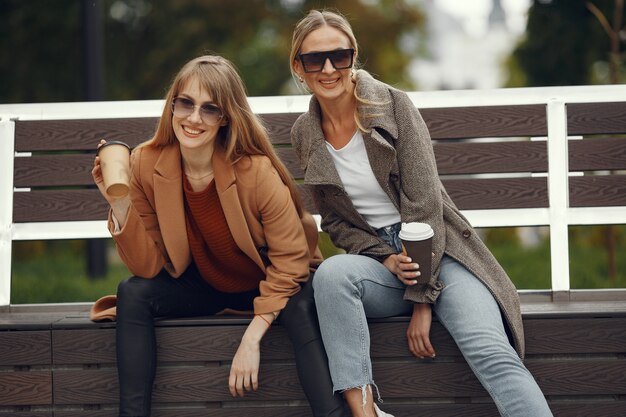 Mädchen sitzen im Frühling und halten Kaffee in der Hand