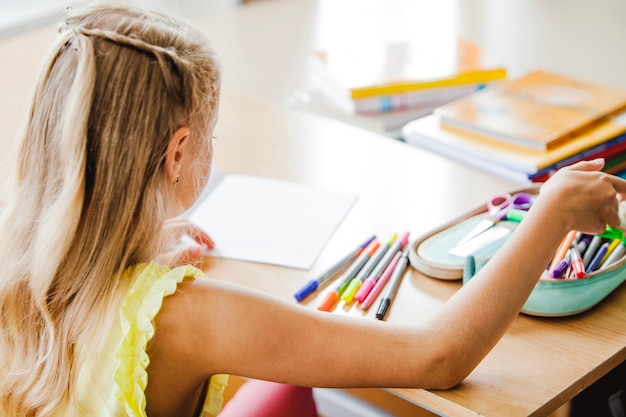 Kostenloses Foto mädchen sitzt am tisch berühren notebook