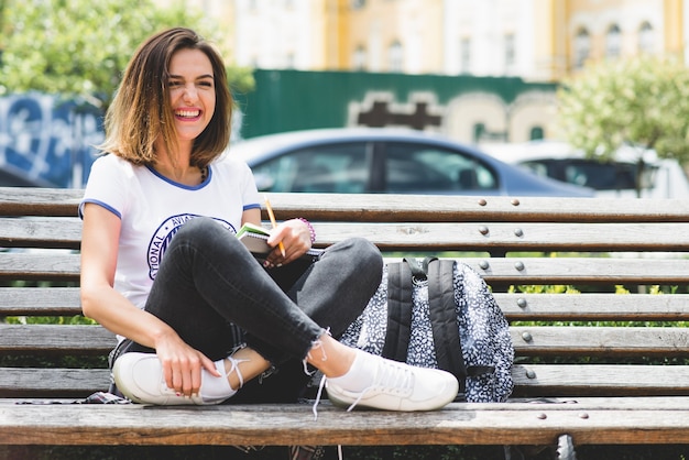 Mädchen sitzt auf der Bank Spaß haben