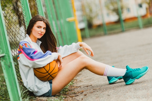 Mädchen sitzt mit Basketball