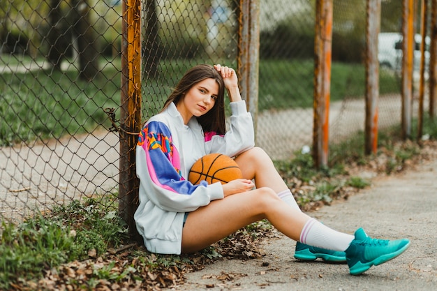 Mädchen sitzt mit Basketball