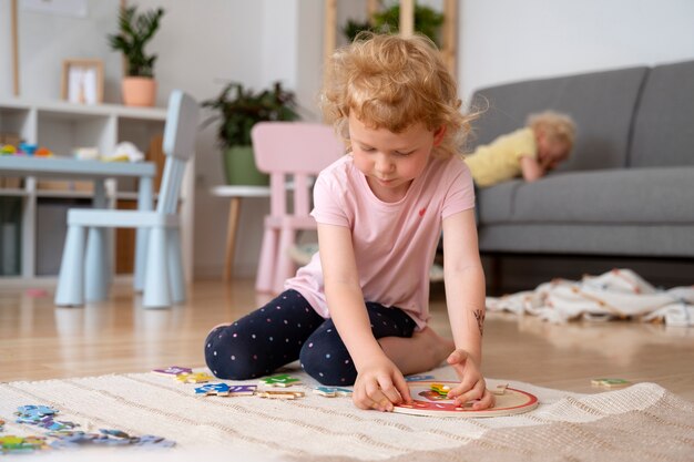 Mädchen spielen auf dem Boden mit Puzzle-Vorderansicht