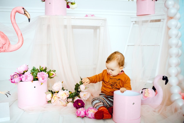 Mädchen spielt mit Blumen im rosa Kasten