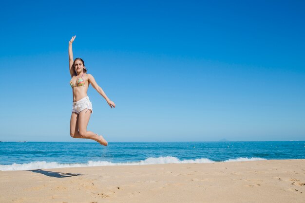 Mädchen springt am Strand