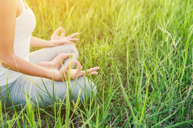 Kostenloses Foto mädchen tun yoga auf dem gebiet sitzt