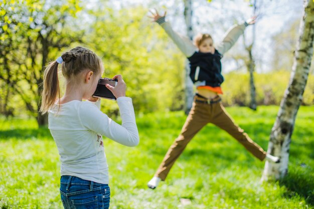 Mädchen üben mit ihrer Kamera im Park