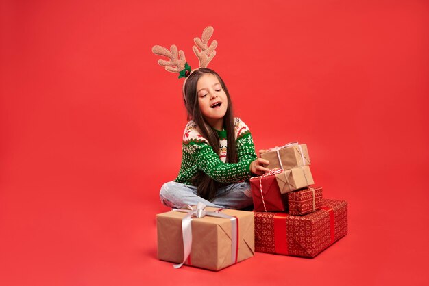 Mädchen und ein Stapel Weihnachtsgeschenke