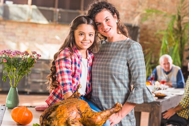 Mädchen und Frau, die nahe gebackenes Huhn umarmt