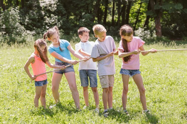 Mädchen und Jungen spielen Tauziehen