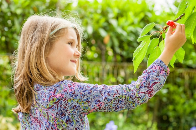 Kostenloses Foto mädchen und kirschbaum mit sommersonne im hintergrund