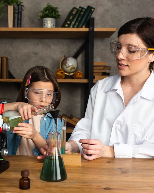 Mädchen und Lehrerin machen wissenschaftliche Experimente mit Reagenzgläsern