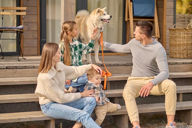 Kostenloses Foto mädchen und mann berühren hund und frau mit kind