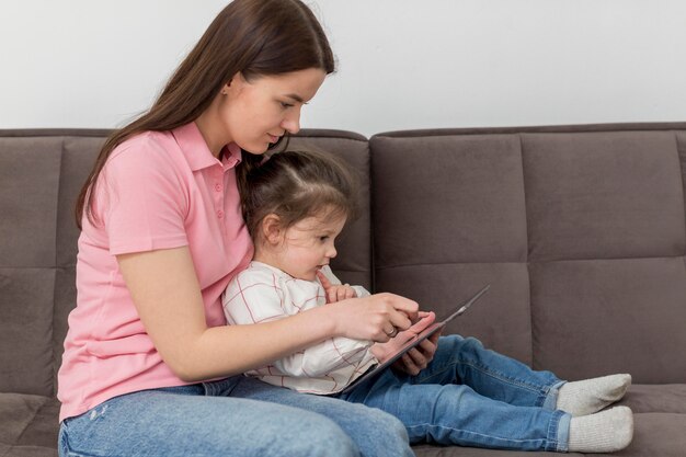 Mädchen und Mutter auf der Couch Seitenansicht