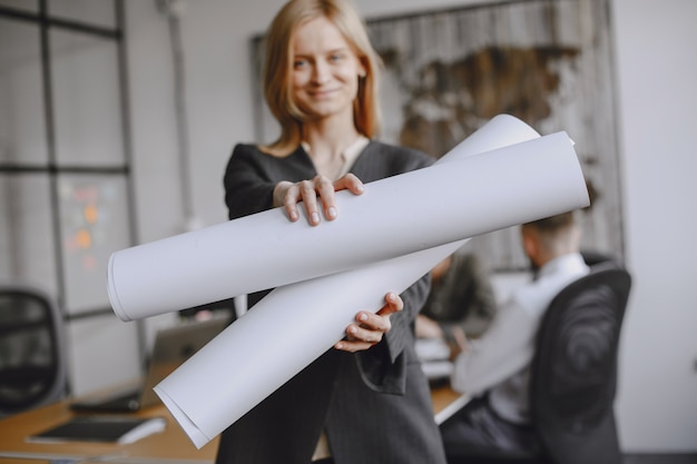 Kostenloses Foto mädchen unterschreibt die dokumente. dame sitzt auf dem tisch. manager arbeitet im büro.