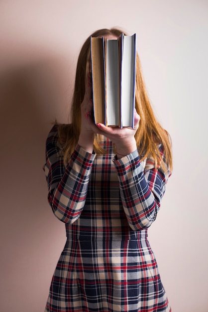 Kostenloses Foto mädchen verstecken ihr gesicht mit mehreren büchern