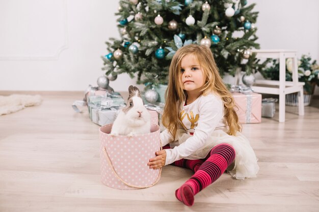 Mädchen vor Weihnachtsbaum zu Hause