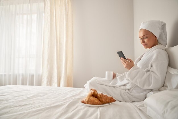 Mädchen wacht auf und benutzt Smartphone