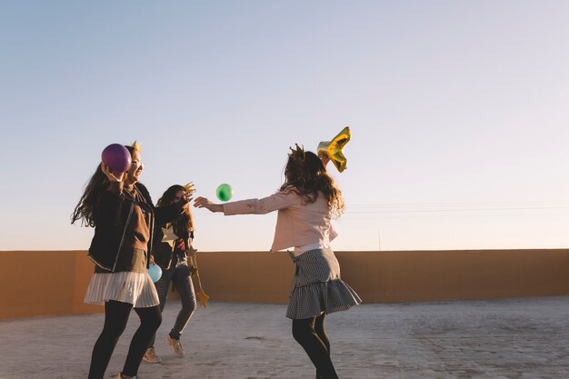 Mädchen werfen Ballons auf dem Dach