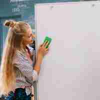 Kostenloses Foto mädchen wiping whiteboard