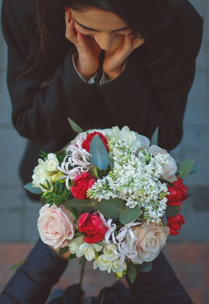 Mädchen wird vom Mann überrascht, der einen Blumenblumenstrauß anbietet