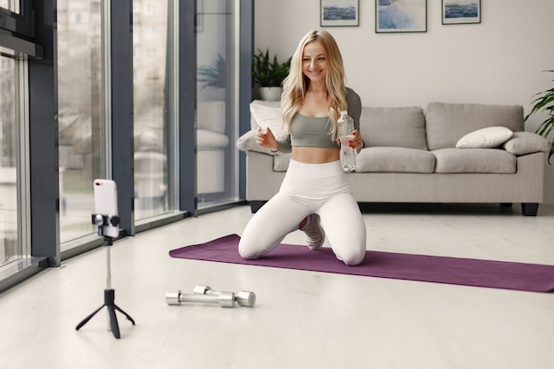 Kostenloses Foto mädchen zu hause. frau machen yoga. lady dreht einen videoblog.