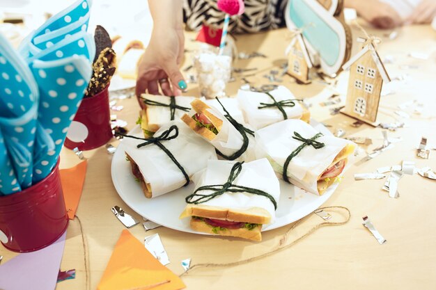 Mädchengeburtstagsdekorationen. Rosa Tischdekoration von oben mit Kuchen, Getränken und Party-Gadgets.