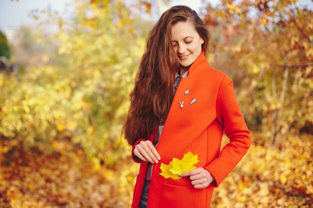 Mädchenporträt, das roten modischen Mantel trägt