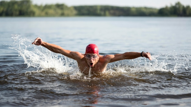 Männchen, das im See schwimmt