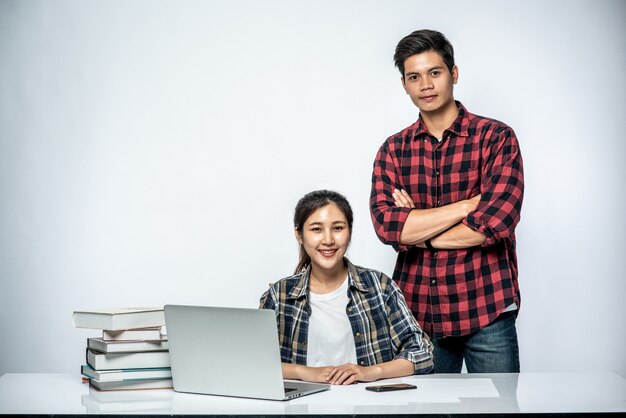 Männer bringen Frauen bei, wie man bei der Arbeit mit Laptops arbeitet.