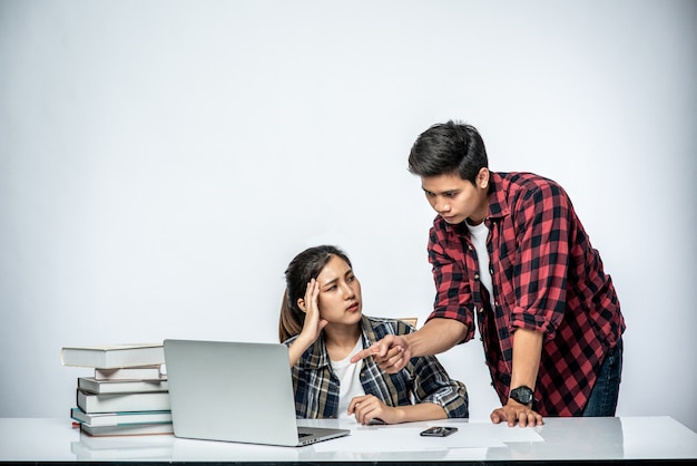 Männer bringen Frauen bei, wie man bei der Arbeit mit Laptops arbeitet.