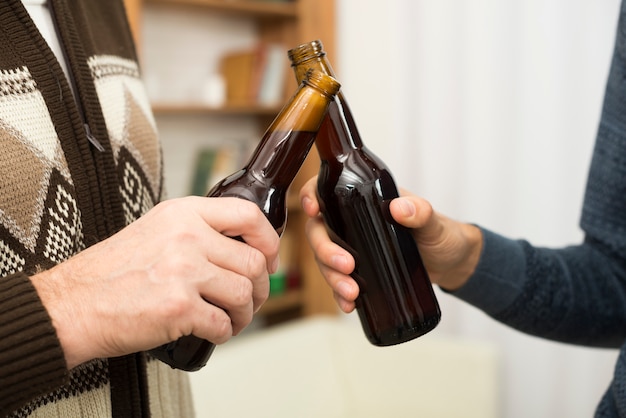 Kostenloses Foto männer, die flaschen alkohol im raum klopfen