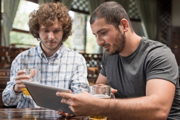 Männer, die Tablette in der Kneipe verwenden