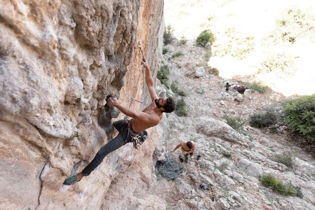 Männer klettern mit Sicherheitsausrüstung auf einen Berg climbing