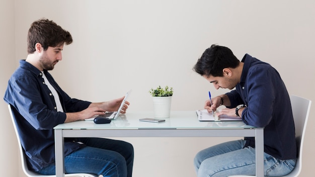 Männer mit Laptop und Notizen machen