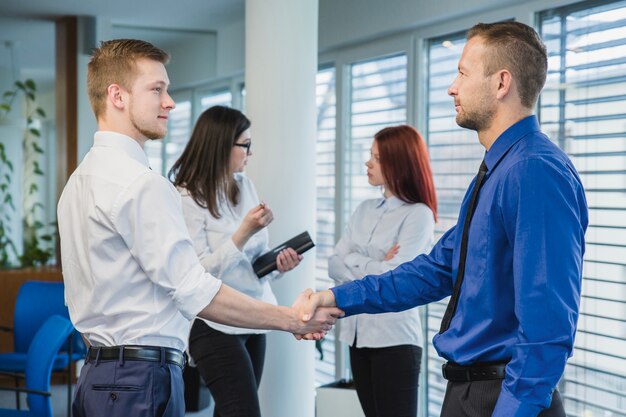 Männer schütteln sich die Hände im Büro