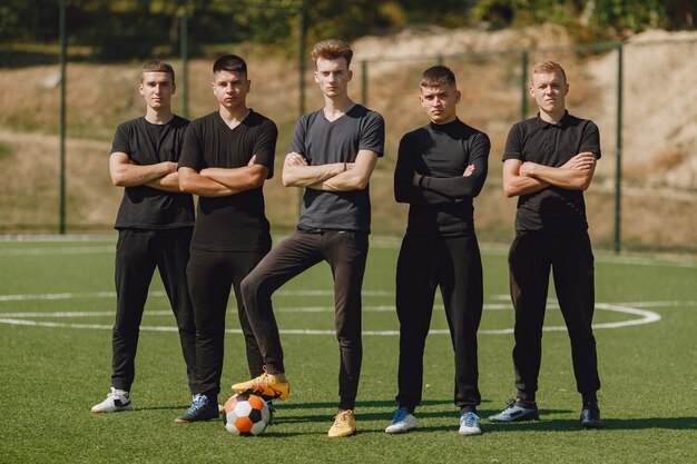 Männer spielen im Park Socer. Turnier auf Mini-Footbal. Kerl in einem schwarzen Sportanzug.