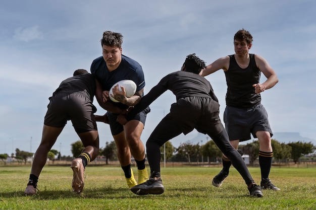 Kostenloses Foto männer spielen rugby auf dem feld