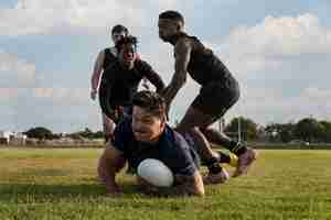 Kostenloses Foto männer spielen rugby auf dem feld
