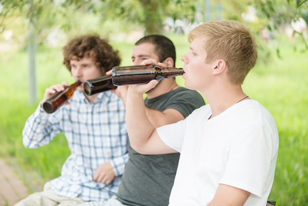 Kostenloses Foto männer trinken bier im park