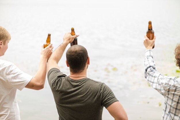 Männer trinken Bier in der Nähe von Wasser