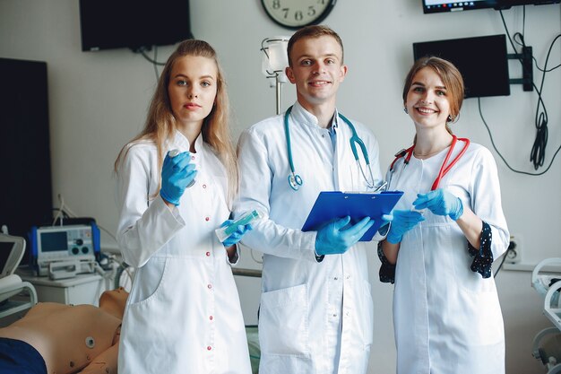 Männer und Frauen in Krankenhauskitteln halten medizinische Geräte in den Händen