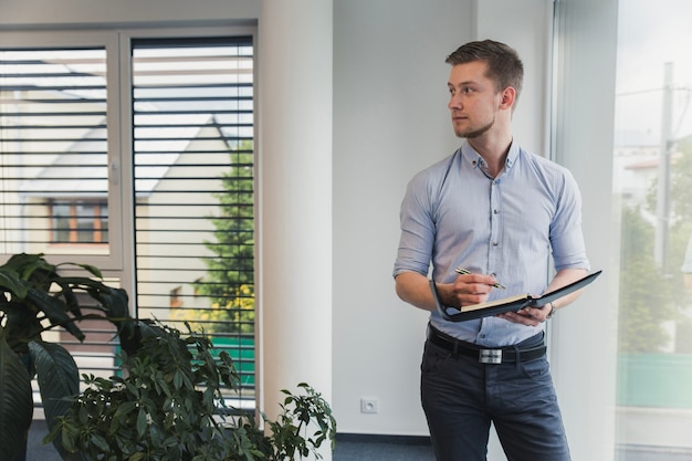 Männliche Arbeiter mit Notizblock im Büro