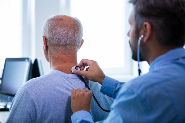 Männliche Arzt einen Patienten untersucht