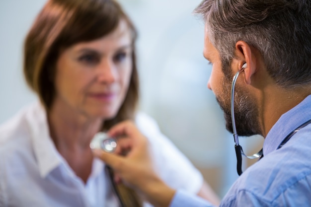 Männliche Arzt einen Patienten untersucht