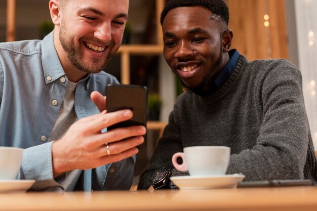 Männliche Freunde der Nahaufnahme, die auf Mobile schauen